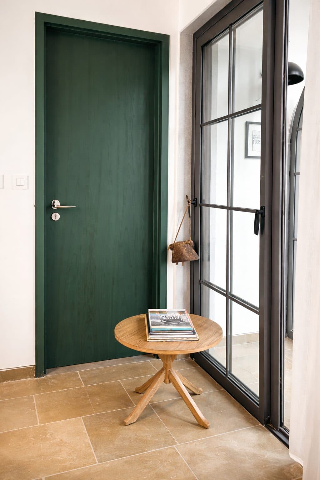 A green veneer door beside a glazed partition